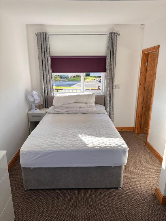 a bedroom with a large bed with a window at F17 Rickardos Holiday Lets in Mablethorpe