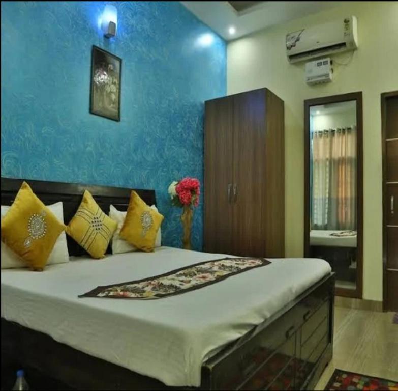 una camera da letto con un grande letto con cuscini gialli di Hotel Sunkriti Resort a Zirakpur