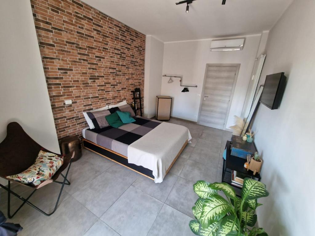 ein Schlafzimmer mit einem Bett und einer Ziegelwand in der Unterkunft Studi011 slow travel in Turin