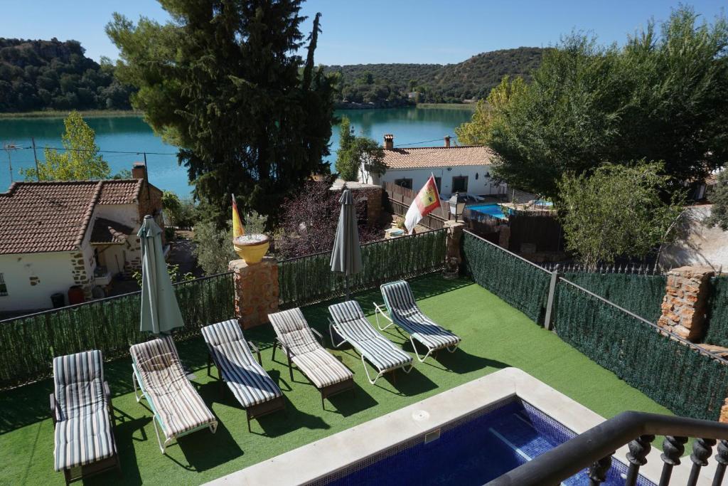 a group of chairs and umbrellas next to a pool at Casa Rural Noel en Parque Natural Lagunas de Ruidera in Ossa de Montiel
