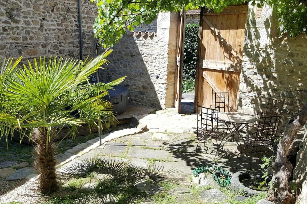 a garden with a table and a chair next to a building at Les papillons in Agnat