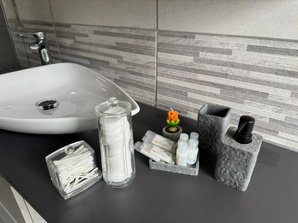 um balcão de casa de banho com lavatório e produtos de higiene pessoal em Casa di Afi, Perfect For 4 - Kitchen - Parking - Netflix em Arona