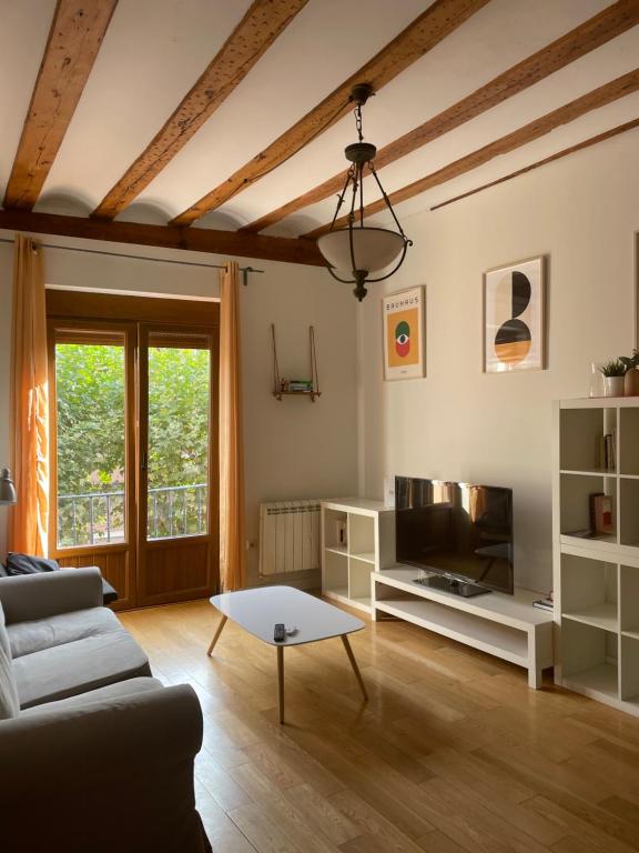 sala de estar con sofá y mesa en Encantador Piso en la Antigua Casa de Correos en Molina de Aragón