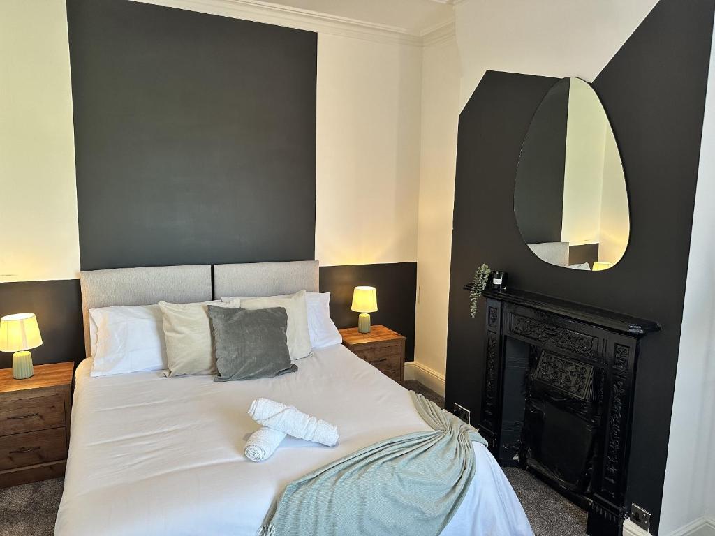 een slaapkamer met een groot wit bed en een spiegel bij 78 Victoria Road in Liverpool