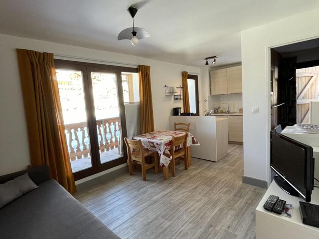 a living room with a table and a kitchen at Appartement Huez, 2 pièces, 4 personnes - FR-1-405-25 in L'Alpe-d'Huez