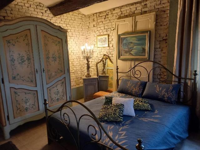 a bedroom with a bed with blue sheets and pillows at La Boheme in Villanova dʼAsti