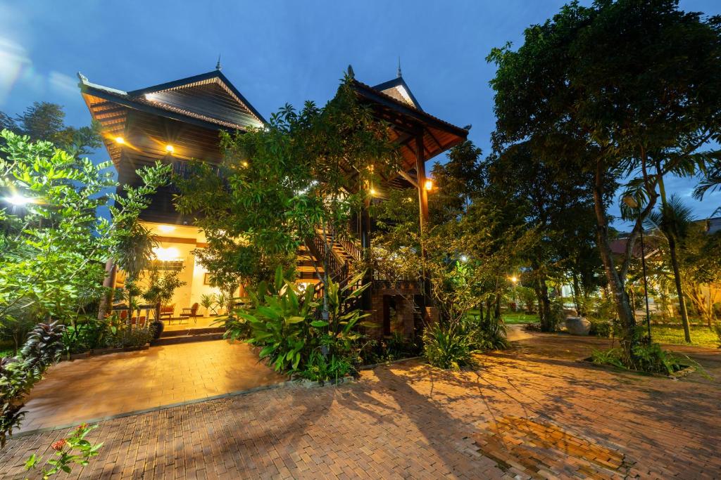 une maison avec un arbre en face dans l'établissement Atoh's Maison, à Siem Reap