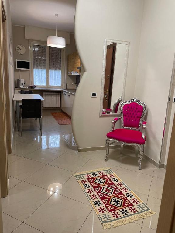 uma sala de estar com uma cadeira vermelha e uma mesa em CASAMAGNOLIA em Cernusco sul Naviglio