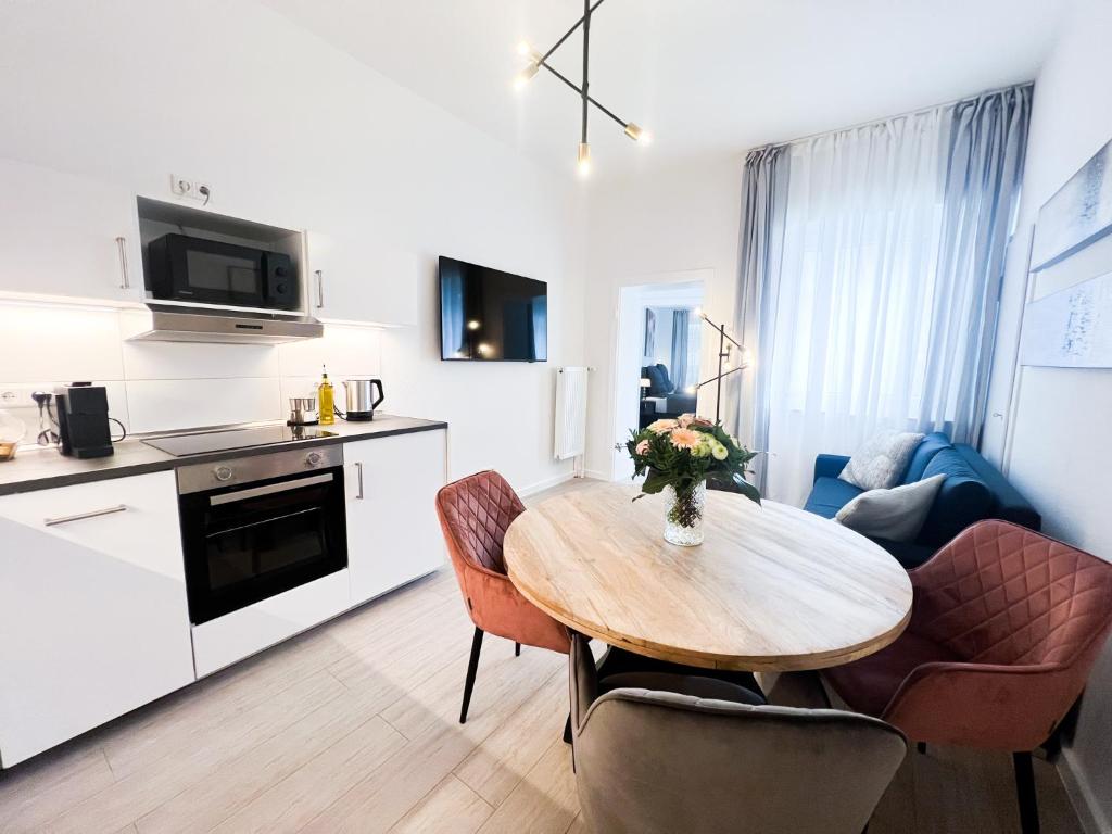 eine Küche und ein Esszimmer mit einem Tisch und Stühlen in der Unterkunft Apartment Düsseldorf City in Düsseldorf