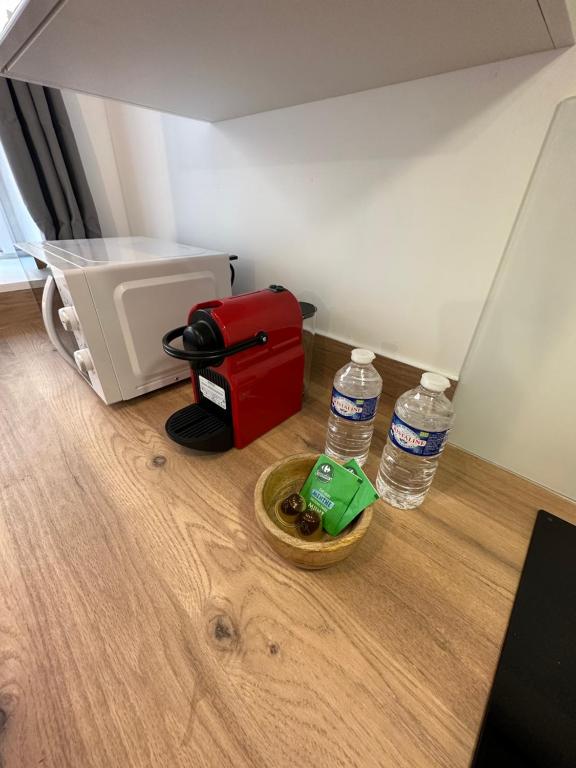 una habitación con una maleta roja y dos botellas de agua en LE VEGETAL / Nay centre, en Nay