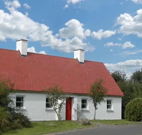 uma casa branca com um telhado vermelho em Longford Holiday Red Rose Self Catering Cottage em Longford