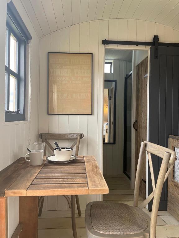 una mesa y una silla en una habitación en Shepherds Huts, en Kidlington