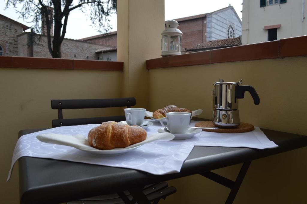 een tafel met twee kopjes koffie en croissants erop bij La Casa di Rachele in Lucca