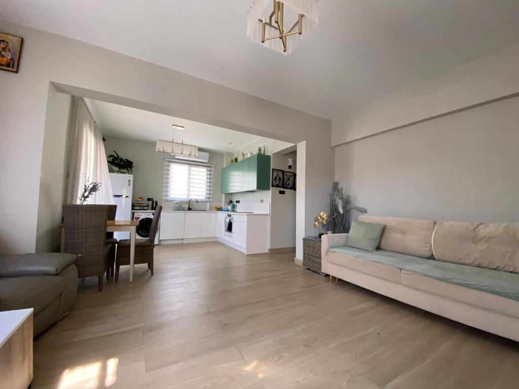 Una sala de estar con un sofá y una cocina. en Faros Beach sea view apart, en Pafos