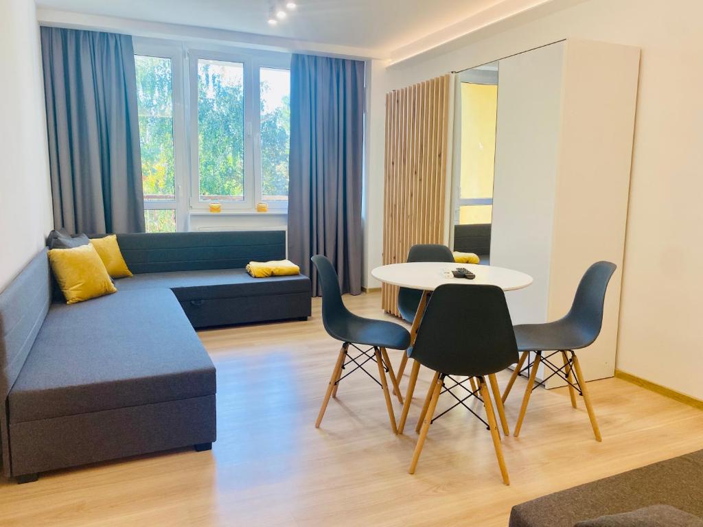 a living room with a couch and a table and chairs at Apartament Świdnik in Świdnik