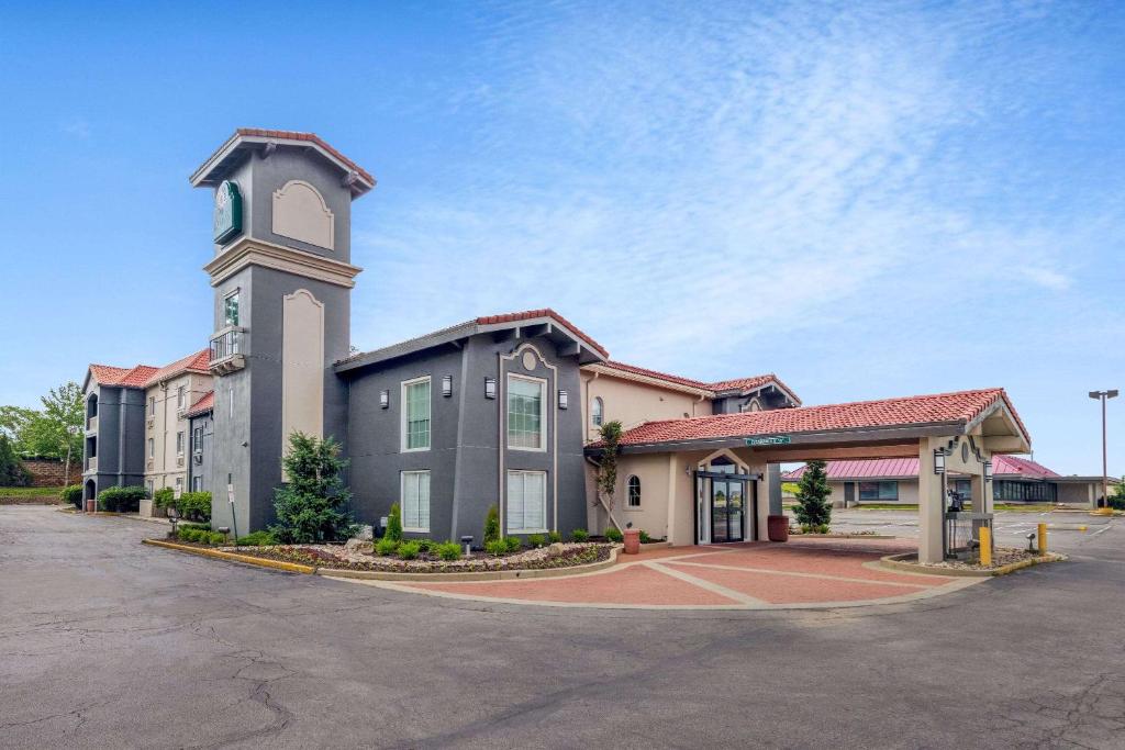 a large building with a clock tower in a parking lot at La Quinta Inn by Wyndham Kansas City Lenexa in Lenexa