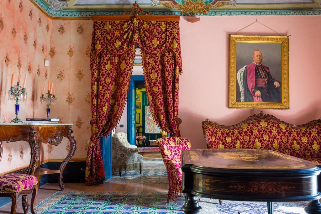 a living room with a painting of a man at Palazzo Previtera in Linguaglossa