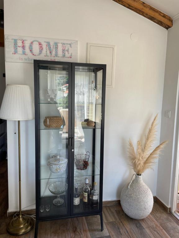 a black glass cabinet in a room with a lamp at Penthouse Damjan in Rab