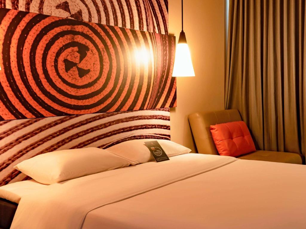 ein Hotelzimmer mit einem Bett und einem Stuhl in der Unterkunft ibis Apartado in Apartadó