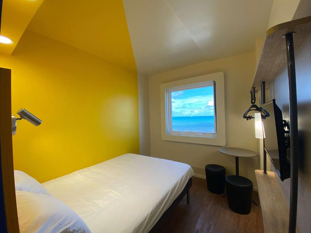 a room with two beds and a window at ibis budget Recife Jaboatão in Recife