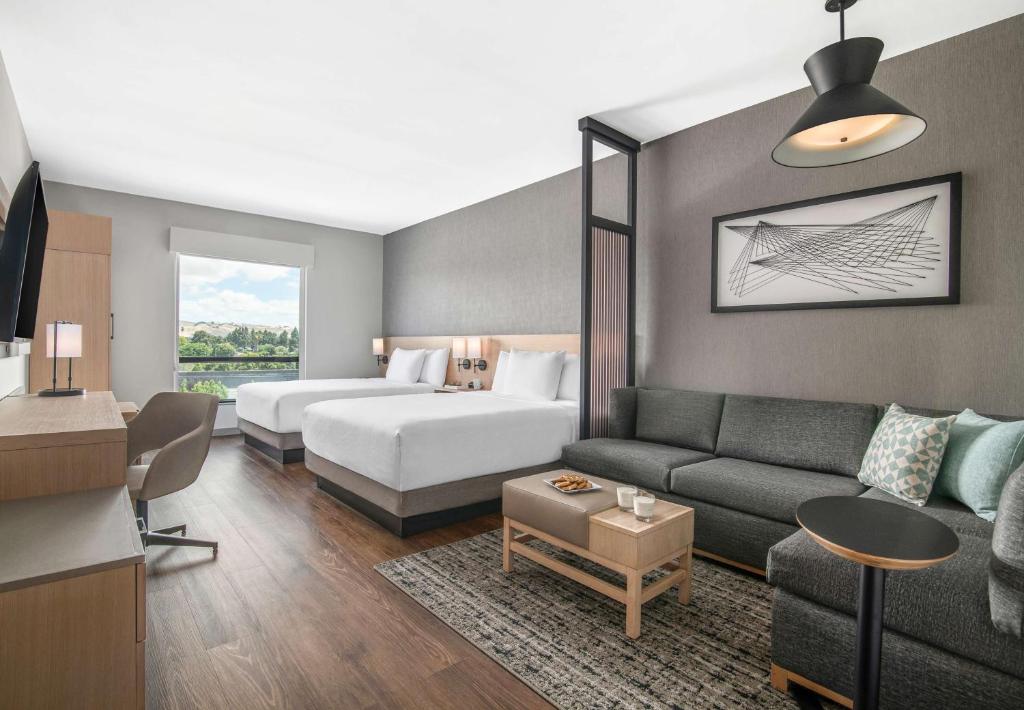 ニューアークにあるHyatt Place Newark-Silicon Valleyのソファとベッド付きのホテルルーム