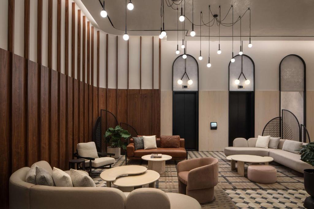 a lobby with couches and tables and chairs at Motto By Hilton New York City Times Square in New York
