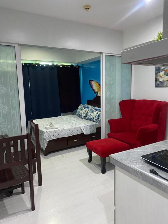 een woonkamer met een rode bank en een bed bij Azure 1bedroom Beachfront in Manilla