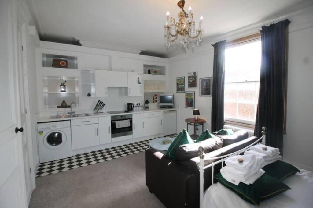 a living room with a couch and a kitchen at City Centre Bolt Hole - Exeter in Exeter