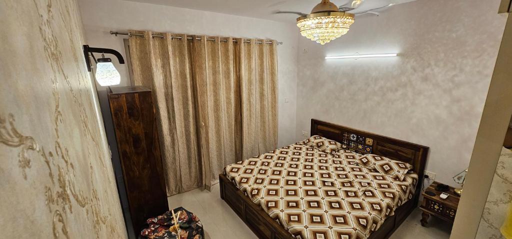 een slaapkamer met een bed en een kroonluchter bij La Grandiose Luxury Serviced Apartments in Bangalore