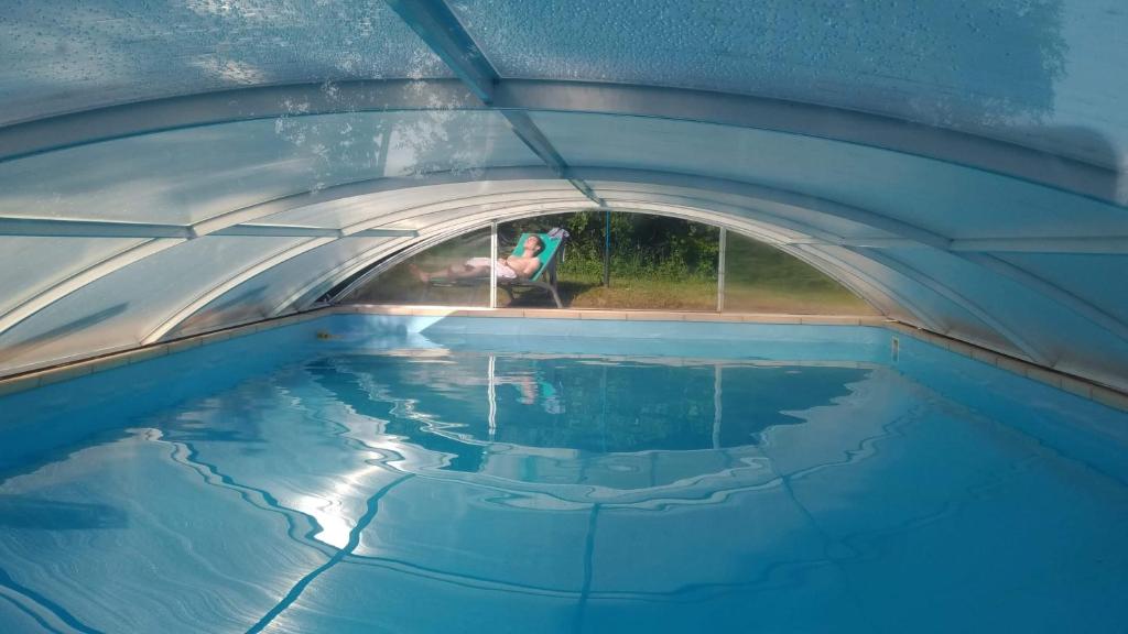een binnenzwembad met een persoon in een tunnel bij LESSENCIEL in Tournay
