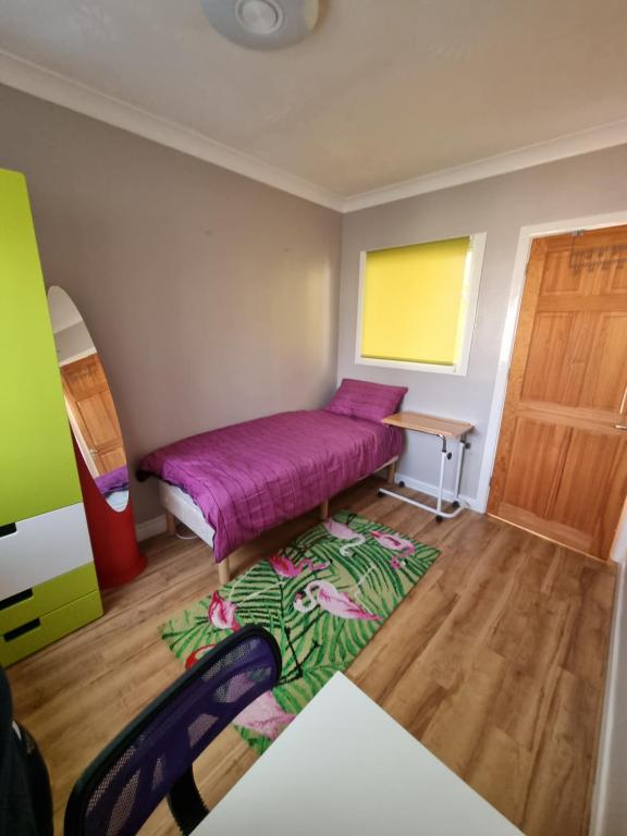 Beautiful guest house في Longham: غرفة نوم صغيرة بها سرير وسجادة