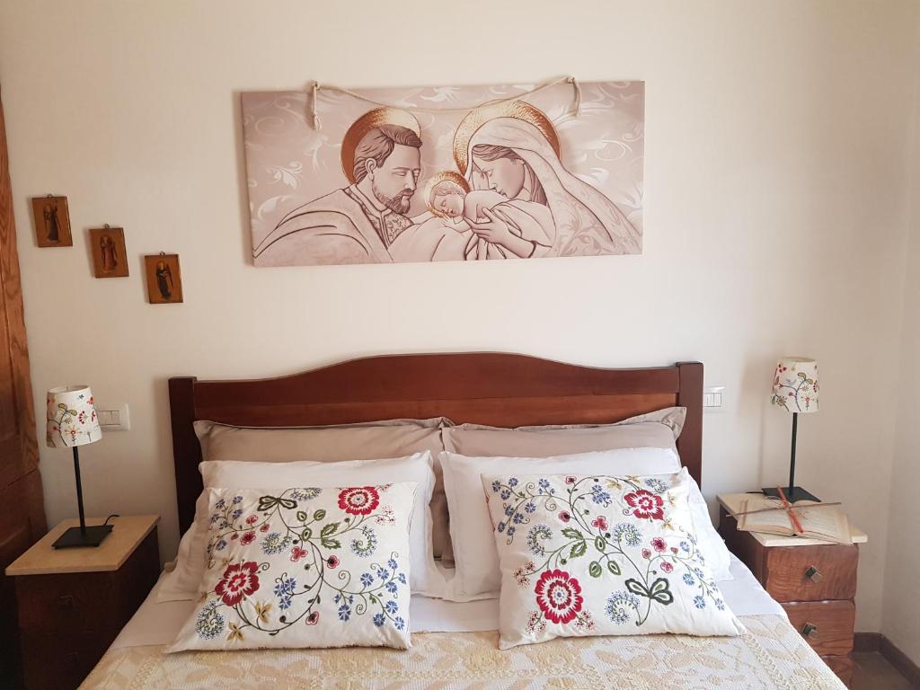 1 dormitorio con 1 cama con una pintura en la pared en Villetta La Pigna, en Castel di Sangro