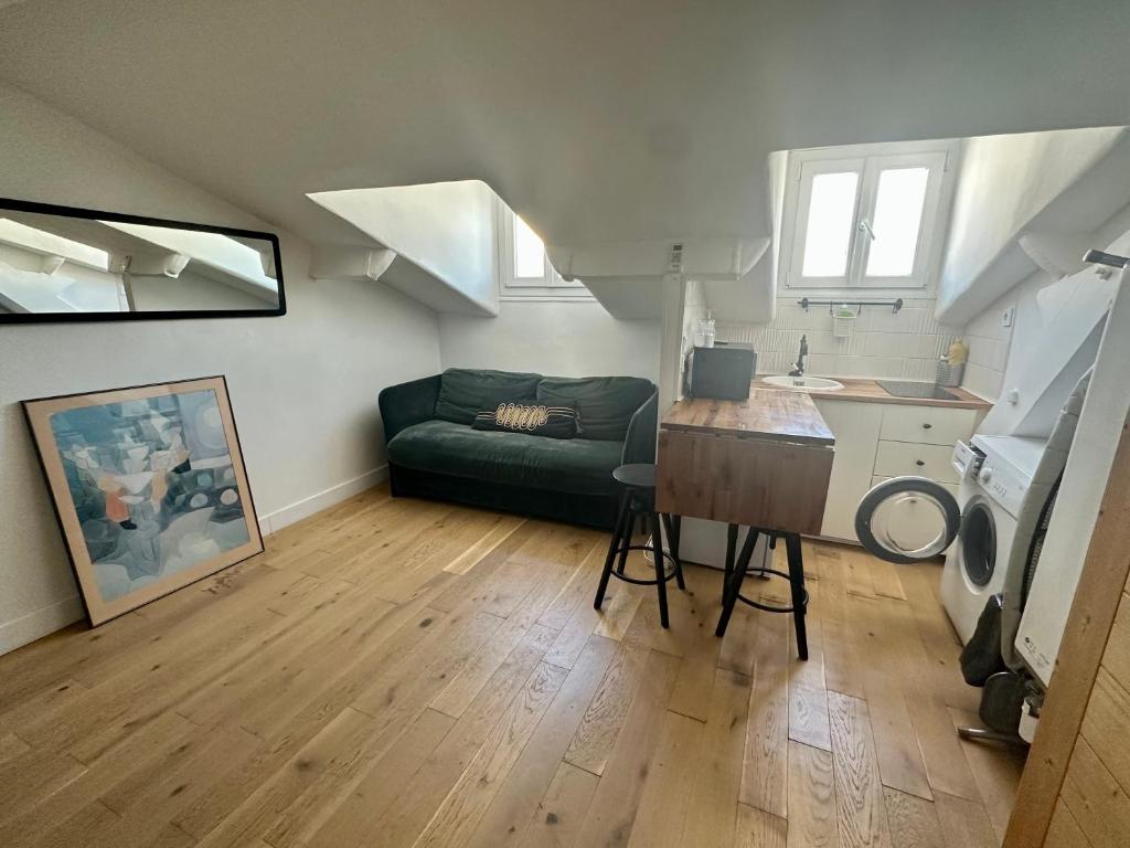 un salon avec un canapé vert et une cuisine dans l'établissement Beau studio au cœur de Nice, à Nice