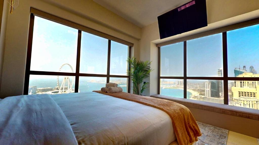 a bedroom with a large bed with large windows at Amazing views Dubai eye & Palm in Dubai