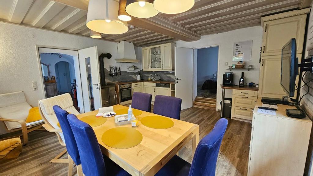 uma cozinha e sala de jantar com uma mesa e cadeiras azuis em Rent a Radl em Trebesing