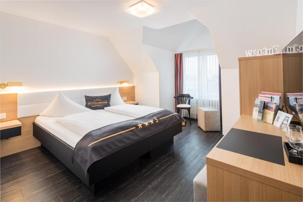 Habitación de hotel con cama y escritorio en 4-Länder-Hotel Deutschmann en Bregenz