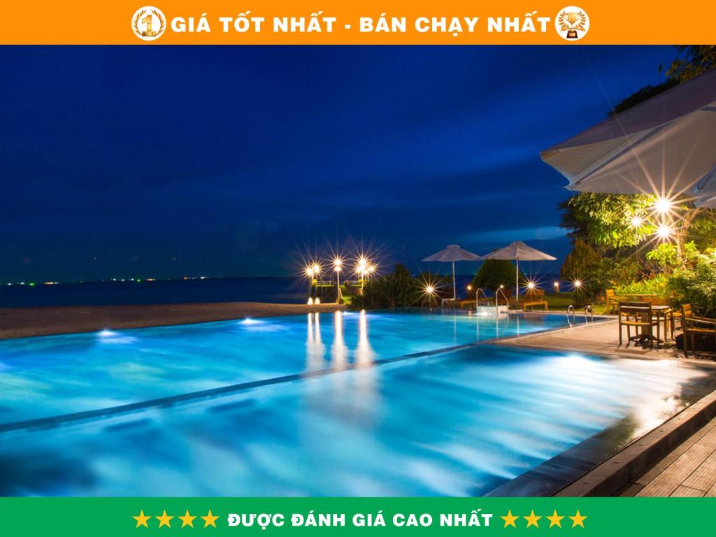 una piscina por la noche con luces encendidas en Chez Carole Beach Resort Phu Quoc en Phu Quoc