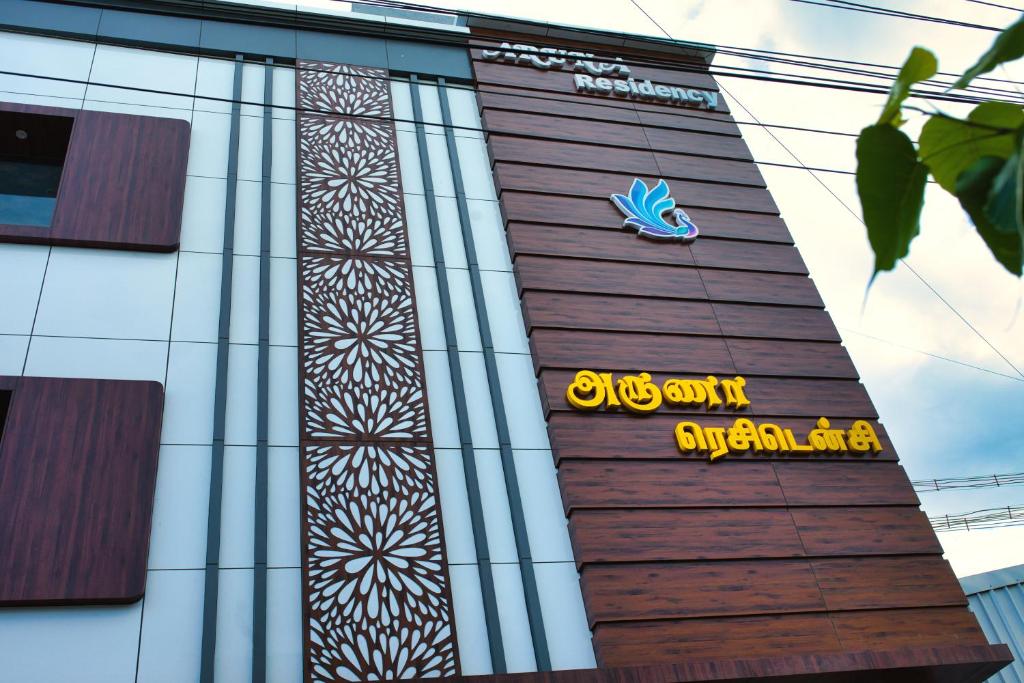 un bâtiment avec un panneau sur son côté dans l'établissement Aruna Residency, à Sankarankovil