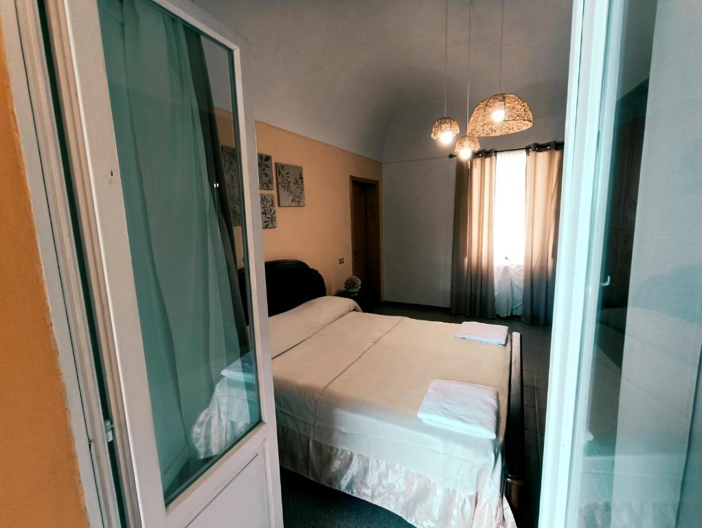een kleine slaapkamer met een bed en een spiegel bij La Finestra sul Corso in Bucchianico