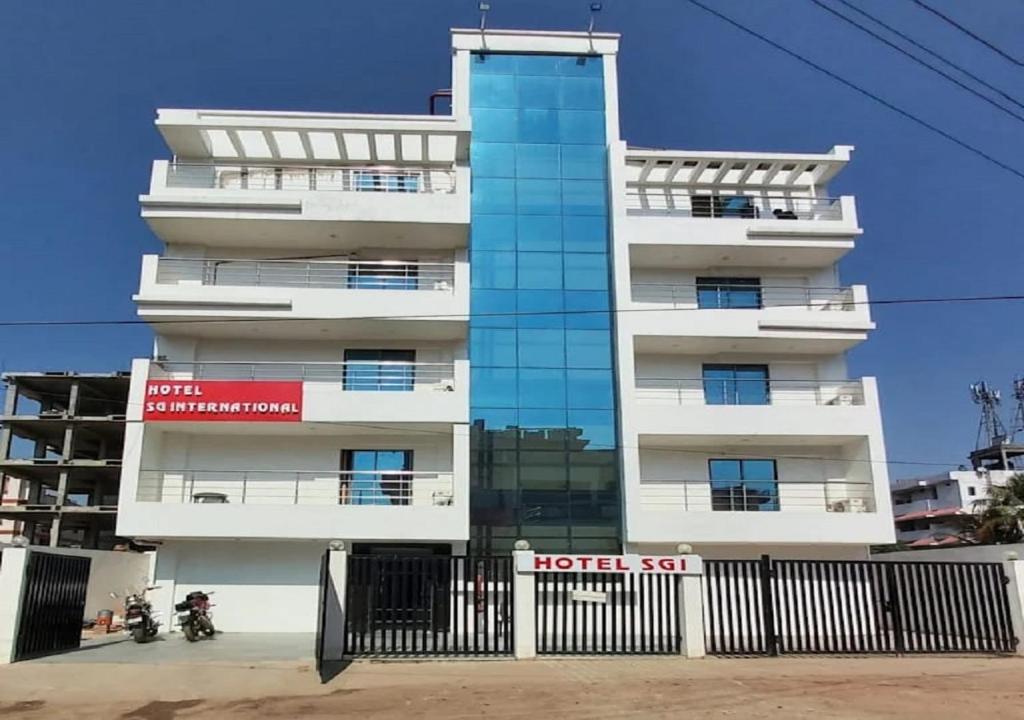 um edifício branco alto com uma cerca preta em frente em Hotel S G International Danapur em Dānāpur