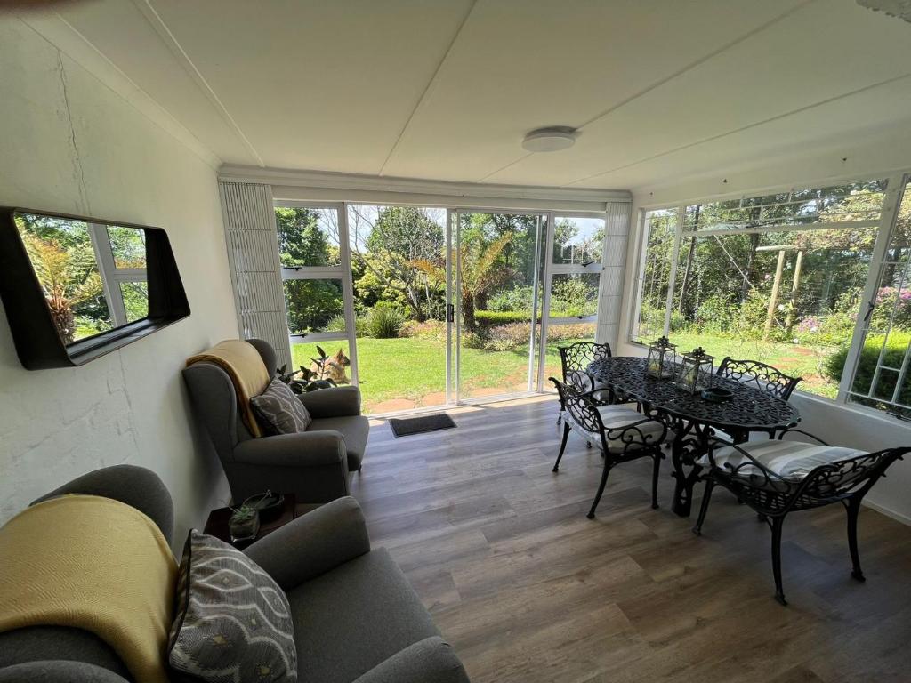 - un salon avec une table et des chaises dans l'établissement Cachai Cottage, à Hilton