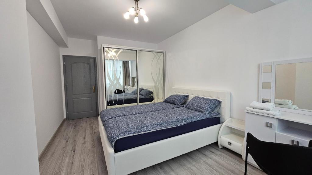 een witte slaapkamer met een bed en een spiegel bij Nordic Residence 28 in Suceava