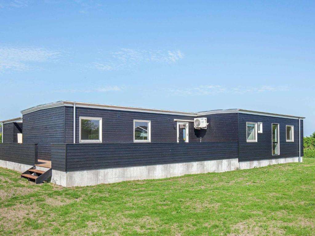 a black modular house with a basketball hoop at 14 person holiday home in Vinderup in Vinderup