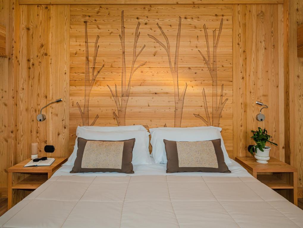 - une chambre avec un grand lit et des murs en bois dans l'établissement Ovindoli Park Hotel & SPA, à Ovindoli