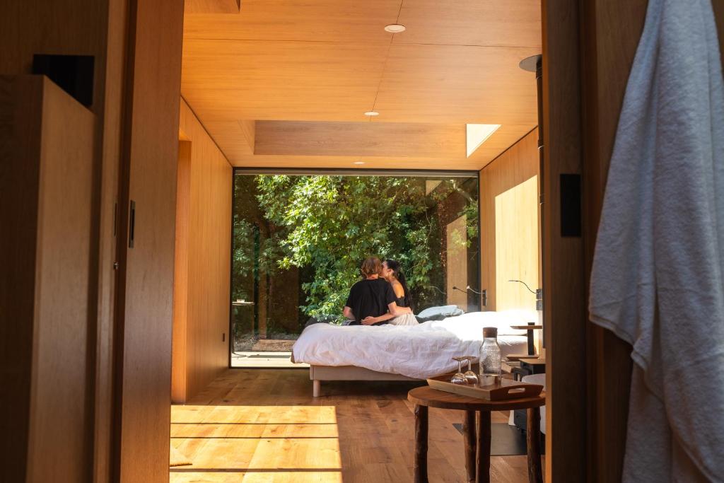 duas pessoas sentadas numa cama num quarto com uma janela em Bleu Minuit La Source em Wolxheim