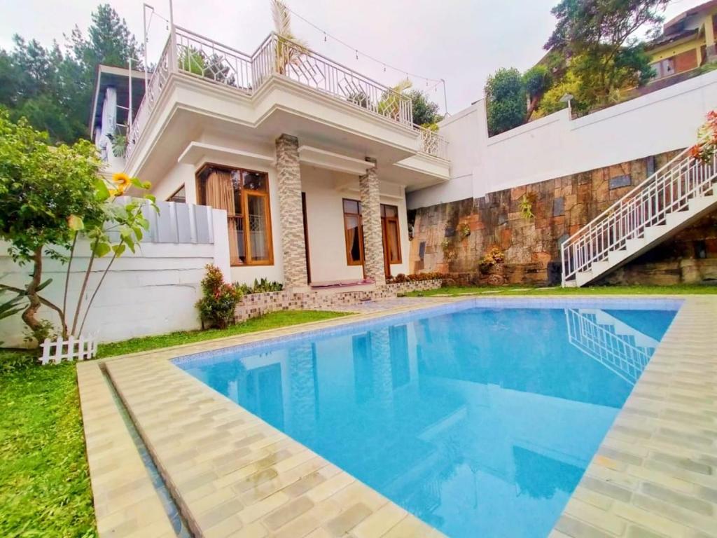 Villa Cisarua Zeni 1 في Brujul: منزل أمامه مسبح