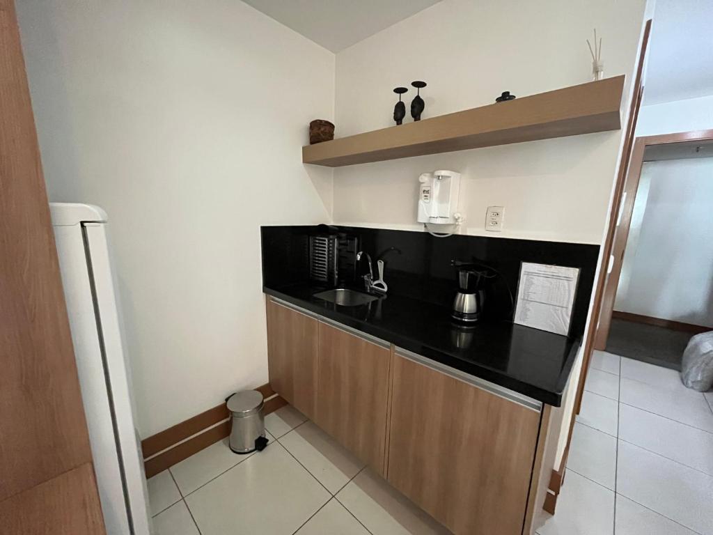 a kitchen with a black counter top in a room at Brasil flats - Athos Bulcão in Brasilia