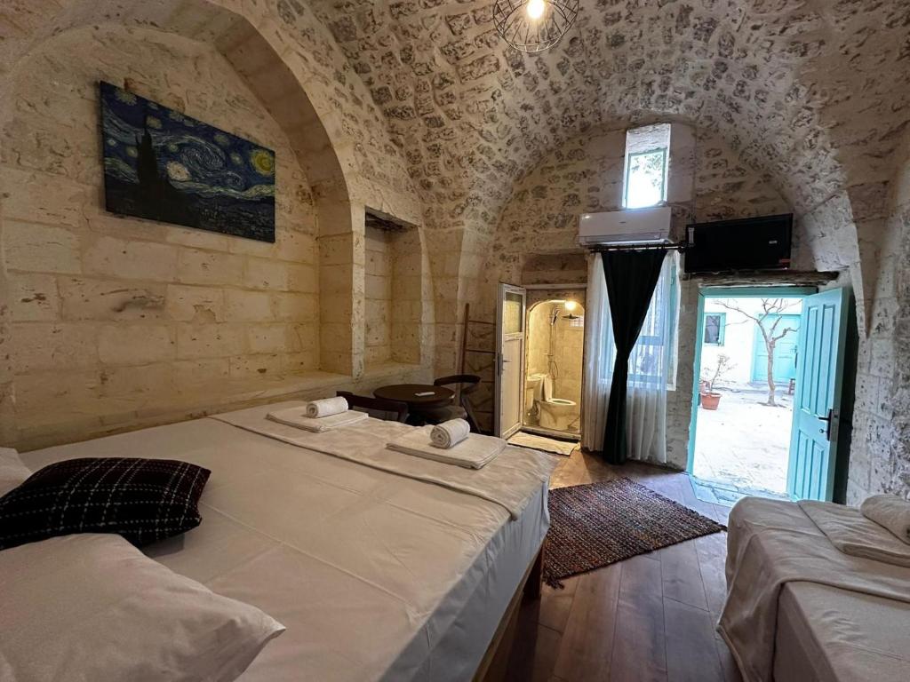 a bedroom with two beds in a room with a window at Petra Hotel & Coffee House in Urfa