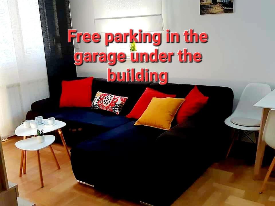 um sofá preto com almofadas vermelhas e amarelas numa sala de estar em Apartment with garage Lavici em Zagreb