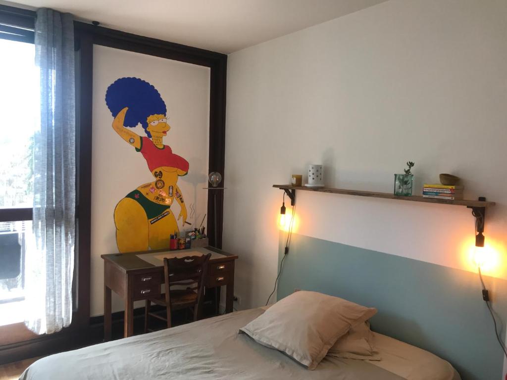a bedroom with a bed and a desk and a painting at Chambre chez l'habitant avec toilettes et salle de bain privatifs in Annecy